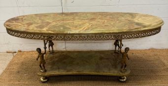 A green marble topped oval coffee table in the Regency style with brass cherub supports (H45cm