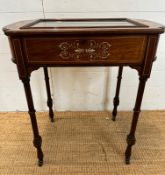 A Victorian bijouterie table with string and scrolling floral inlay on turned legs and castors