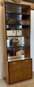 A contemporary mirror backed bookcase with four shelves and a two door cupboard under (H244 W85cm