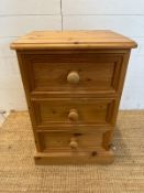 A pine three drawer bedside table (H65cm W45cm D38cm)