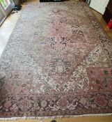 An Iranian Persian Heriz red background blue boarder wool rug, 295cm x 415cm Condition Report fading