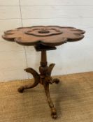 A pedestal tilt top bird cage table in the Georgian style on carved tripod legs featuring eagle