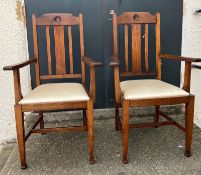 A pair of oak Arts and Crafts style arm chairs with drop in seats Circa 1905