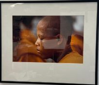 A framed photographic portrait of a young timed Buddhist Monk 61cm x 51cm