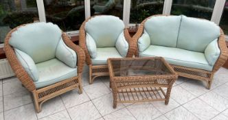 A four piece conservatory suite consisting of two seater sofa, two arms chairs and one table (