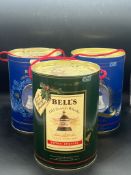 Three commemorate bottles of Bells whiskey, the porcelain decanters all still in their drum