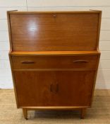 A teak Mid Century bureau, single long drawer with cupboard under. The fall opening to two small