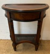 A Demi Lune side table with fluted legs and cane shelf under