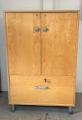 A contemporary office cabinet, two doors opening to four shelves and a filing cabinet to bottom (