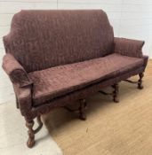 A French style high back sofa on ornate carved legs and upholstered in a purple fabric featuring