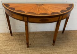 A Demi Lune side table with veneered top on tapering legs (H73cm W130cm D47cm)
