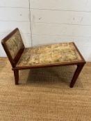 An oak folding gout stool in a pastoral upholstery