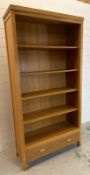 A contemporary four shelf wooden bookcase with one long drawer under (H197cm W100cm D35cm)