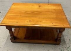 A pine coffee table on turned legs with shelf under (H49cm W92cm D60cm)