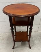 A mahogany side table with circular top and two lower shelves on out swept legs (H73cm Dia50cm)