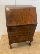 A reproduction bureau on cabriole legs (H107cm W61cm D42cm)