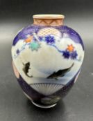 A small Japanese vase in baluster form. Blue grounds and decorated with flowers and fish Height
