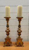 A pair of wooden gold painted candle sticks in the rococo style
