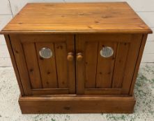 A pine side cabinet opening to shelves and cut out back (H58cm W68cm D43cm)