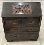 A Mid Century hardwood bureau, heavily carved with far Eastern scenes (H106cm W92cm D43cm)