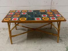 A Mid Century multi coloured tile topped table on bamboo legs (H43cm W89cm D45cm)