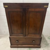 An oak two door linen cupboard in the campaign style with a mahogany veneer, the doors opening to
