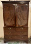 A mahogany linen press. Two doors opening to five shelves with a two over two chest under. AF.