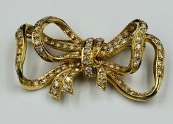 A Diamond and 18ct Gold Late Twentieth Century Bow brooch. Approximate combined diamond weight of