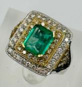 An emerald and diamond three tier square cluster ring with diamond set shoulders.Central emerald cut