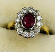 A ruby and diamond daisy ring on an 18ct yellow gold setting, approximate size L.5