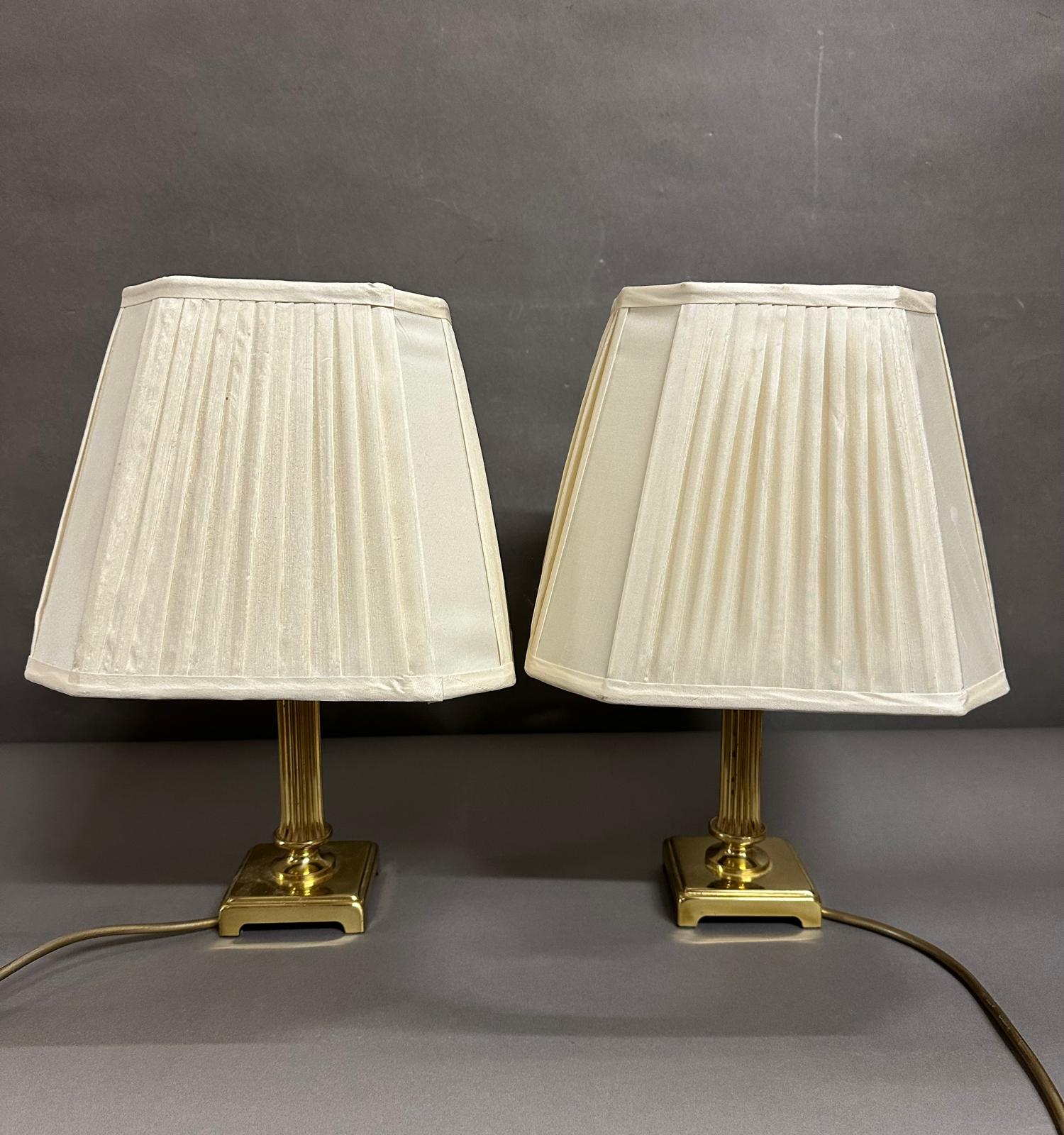 A pair of squat brass empire column table lamps