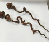 A pair of metal wall hanging candle holders in the form of snakes