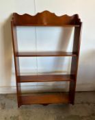 A mahogany veneered four shelf wall hanging shelving unit