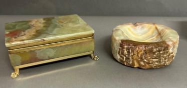 An onyx cigarette box on brass lion paw feet and an onyx ash tray