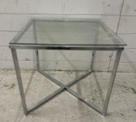 A glass topped side table on chrome X frame base (H45cm W50cm D50cm)