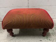 A gold and red striped foot stool