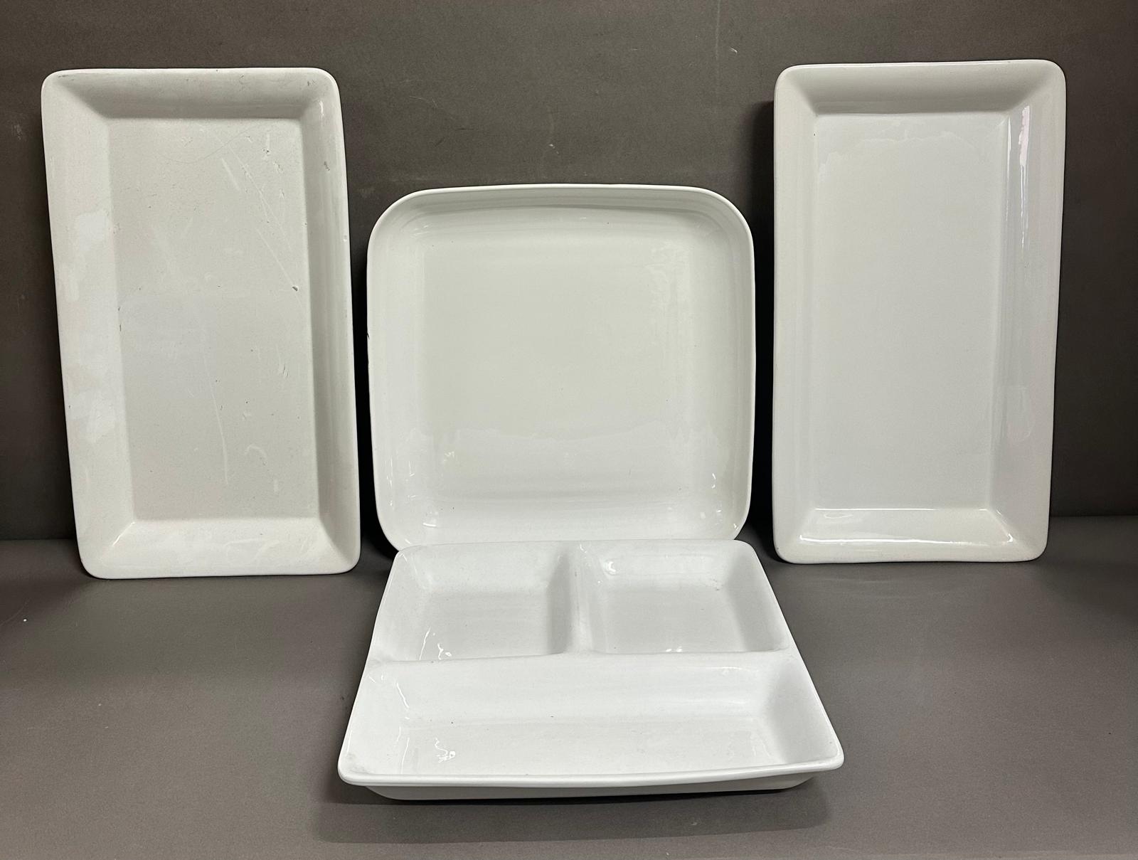 Four large white ceramic serving dishes
