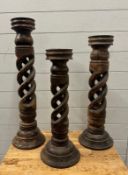 Three turned and twisted wooden candle pillars(Tallest H69cm)