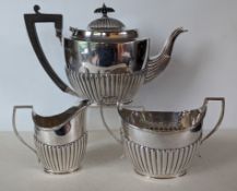 An Edwardian silver three-piece tea service with half fluted embossed design