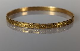A yellow gold bangle with carved decoration, 65mm, stamped and tests for 22ct, 15g