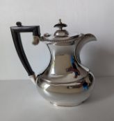 A QEII silver coffee or water pot of bulbous form with wood handles on a raised base