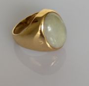 An 18ct yellow gold oval jade-set ring with tapering shank, size O, hallmarked, 13.4g