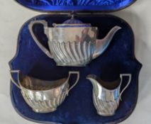 A late Victorian silver three-piece tea set with half flute embossed decoration, hallmarked 