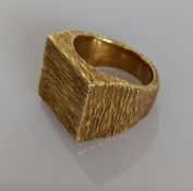 A mid-century yellow gold oblong dress ring with textured design, stamped and tests for 18ct, size N