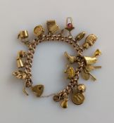 A flat curb-link gold charm bracelet with heart clasp, each link and charm hallmarked 9ct, 14 cm