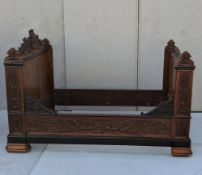 An early 19th century walnut and ebonised French day bed with elaborately carved Paris coat of arms 