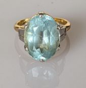 An oval aquamarine dress ring on an 18ct yellow gold and platinum claw setting