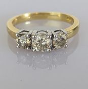 A three-stone, brilliant-cut graduated diamond ring on a yellow gold claw setting