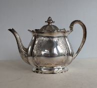 An Edwardian silver teapot of squat form with floral and foliate etched decoration on a raised base