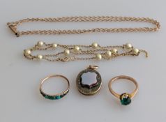 A turquoise ring on a rose gold setting, an emerald ring in a yellow gold claw setting, a fob medal 
